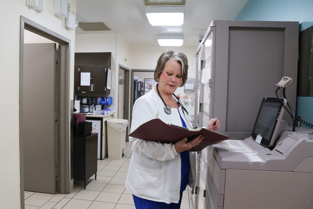 A health care worker reads over a patient's chart.