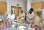 A professor shows three students how to run a test.