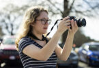 girl in blue shirt holding camera