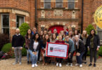 Junemester undergraduate students pose with a University of Georgia flag in front of the UGA at Oxford Centre (Photo by Andrew Davis Tucker/UGA)